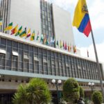 Fachada del Banco Central del Ecuador con banderas en el exterior.