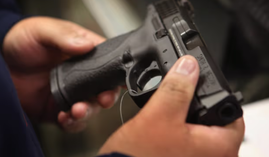 Primer plano de unas manos que manipulan una pistola.