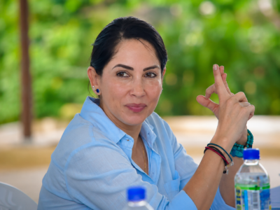 Luisa González sentada a una mesa durante una reunión.
