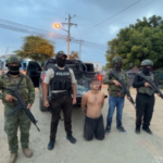 Agentes uniformados acompañan a un hombre durante un procedimiento policial.