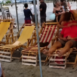 Personas junto a sillas de playa en una zona turística de Cojimíes.