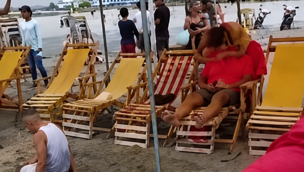 Personas junto a sillas de playa en una zona turística de Cojimíes.