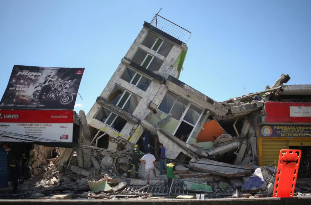Edificio inclinado y estructuras dañadas junto a una calle.