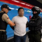 Dos agentes acompañan a un hombre en una estación del Metro de Quito.