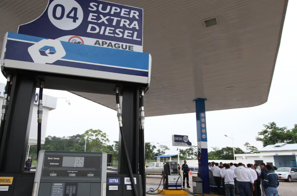 Estación de servicio con surtidores de combustible y una cubierta azul.