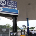 Estación de servicio con surtidores de combustible y una cubierta azul.