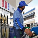 Trabajador de una estación de servicio abastece de combustible a un vehículo.