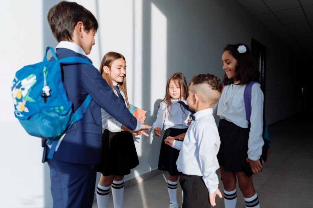 Niño con mochila junto a personas adultas en un espacio escolar.