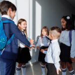 Niño con mochila junto a personas adultas en un espacio escolar.