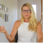 Mujer con gafas interviene en un espacio interior.
