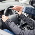 Instructor acompaña a una persona que practica la conducción de un vehículo.