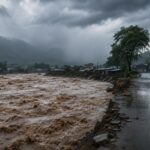 Río crecido junto a una carretera bajo un cielo de tormenta.
