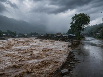 Río crecido junto a una carretera bajo un cielo de tormenta.