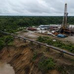 Instalaciones de extracción petrolera rodeadas de vegetación.