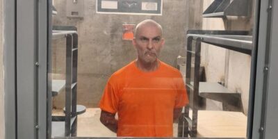 Hombre con uniforme naranja dentro de un recinto penitenciario.