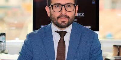 Retrato de Aldrin Gómez sentado en una oficina.