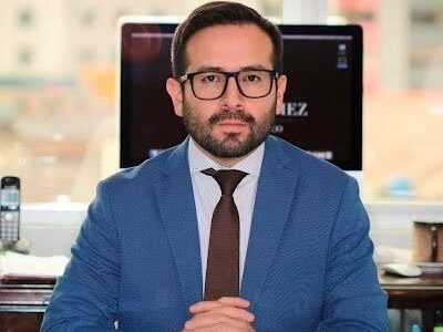Retrato de Aldrin Gómez sentado en una oficina.