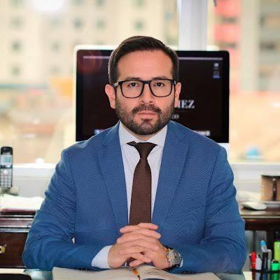 Retrato de Aldrin Gómez sentado en una oficina.