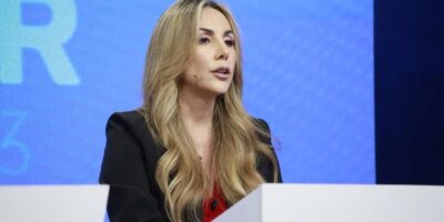 Gisella Bayona interviene ante un micrófono en un escenario.