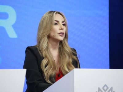 Gisella Bayona interviene ante un micrófono en un escenario.