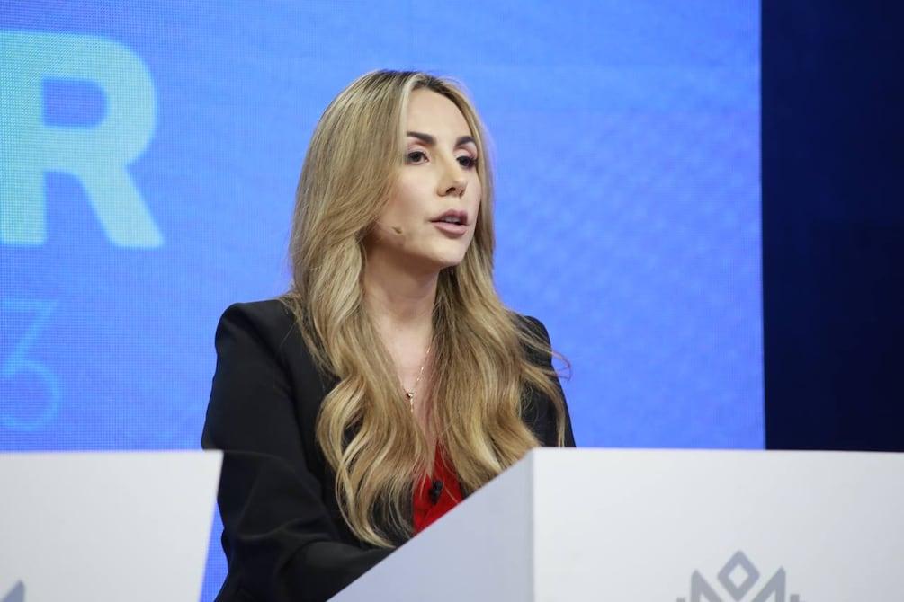 Gisella Bayona interviene ante un micrófono en un escenario.