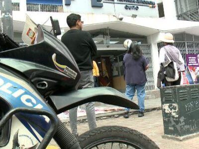 Motocicleta policial junto a personas y un vehículo de atención de emergencias.