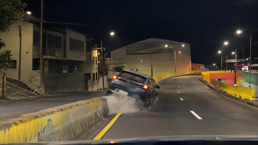 Captura de un vehículo que circula por una avenida durante la noche.