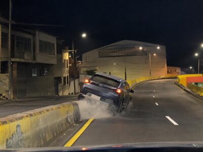 Captura de un vehículo que circula por una avenida durante la noche.
