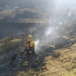 Bombero trabaja en una ladera afectada por un incendio forestal.