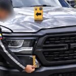 Agente inspecciona la parte delantera de una camioneta Ram.