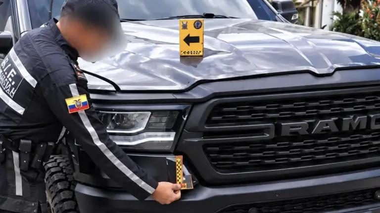 Agente inspecciona la parte delantera de una camioneta Ram.
