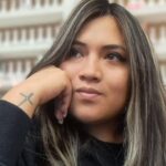 Retrato de una mujer que apoya la cabeza sobre una mano.