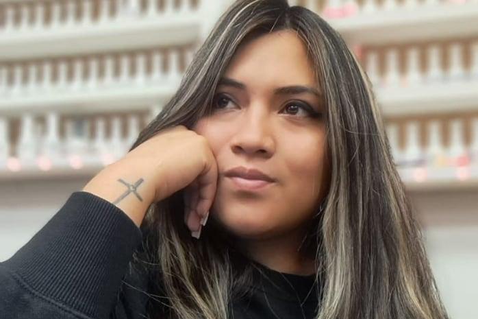 Retrato de una mujer que apoya la cabeza sobre una mano.