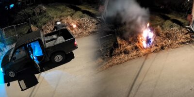 Captura nocturna con un vehículo estacionado y fuego en un área de vegetación.