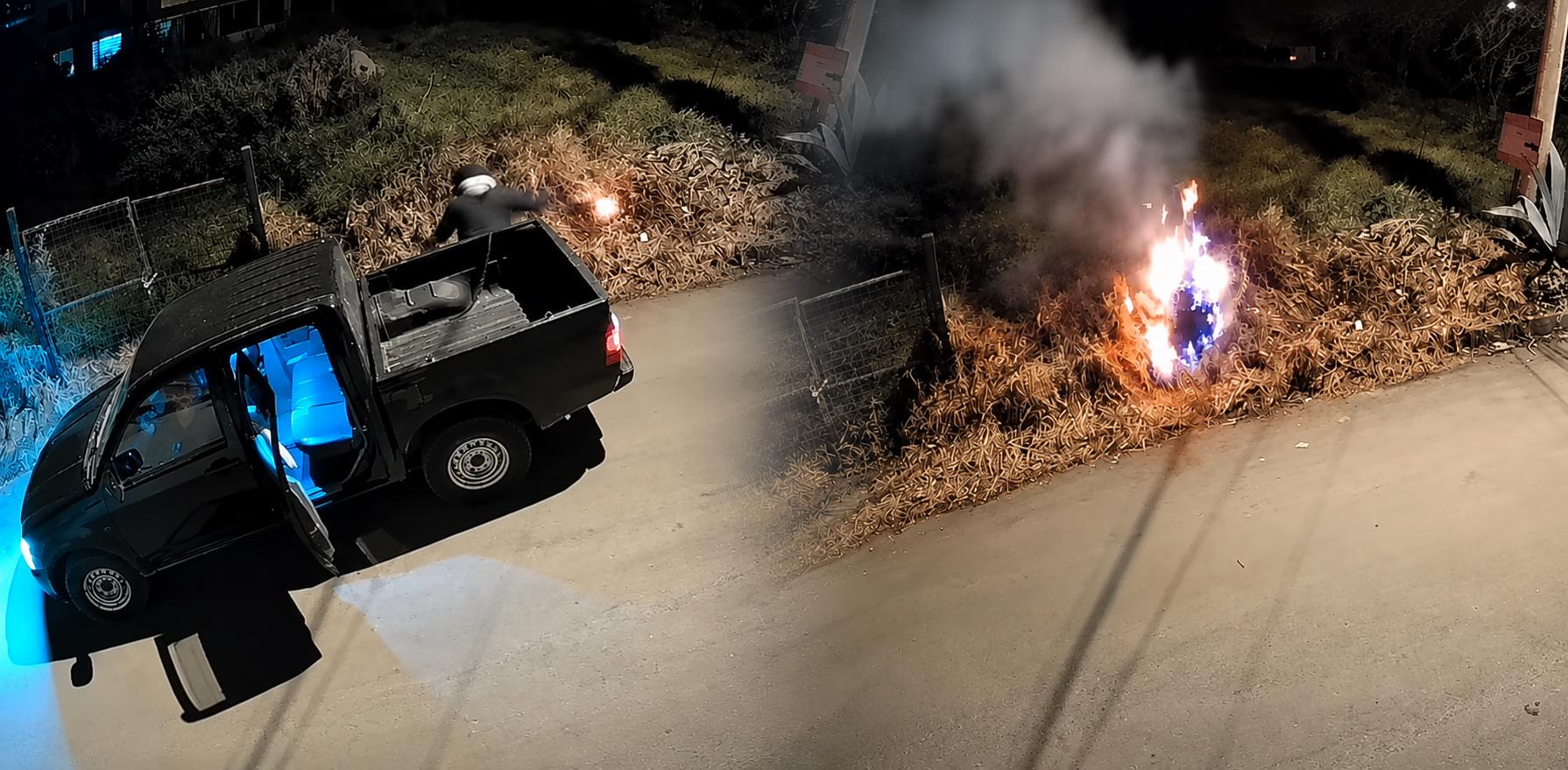 Captura nocturna con un vehículo estacionado y fuego en un área de vegetación.