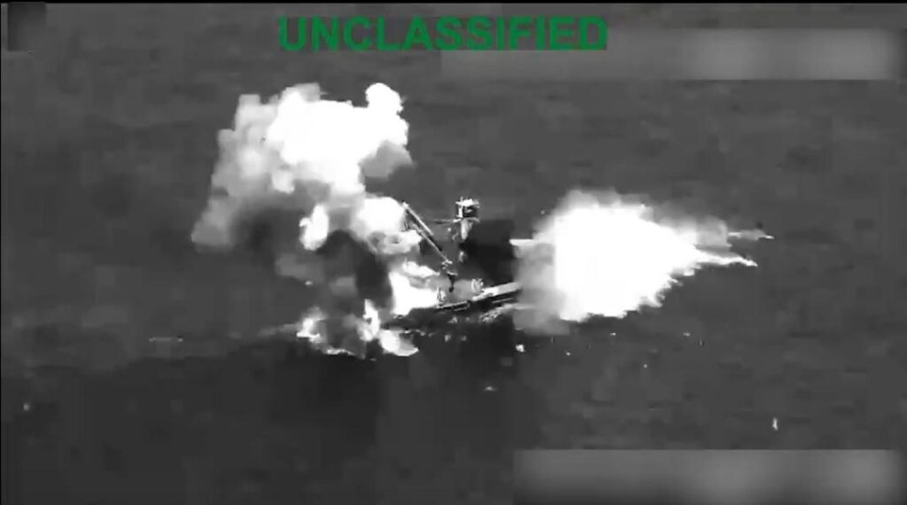 Captura aérea en blanco y negro de una embarcación envuelta en humo y llamas.