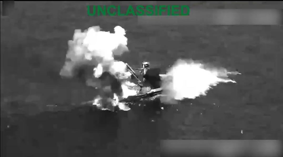 Captura aérea en blanco y negro de una embarcación envuelta en humo y llamas.