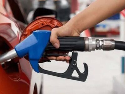 Una persona introduce un surtidor de combustible en el depósito de un vehículo.