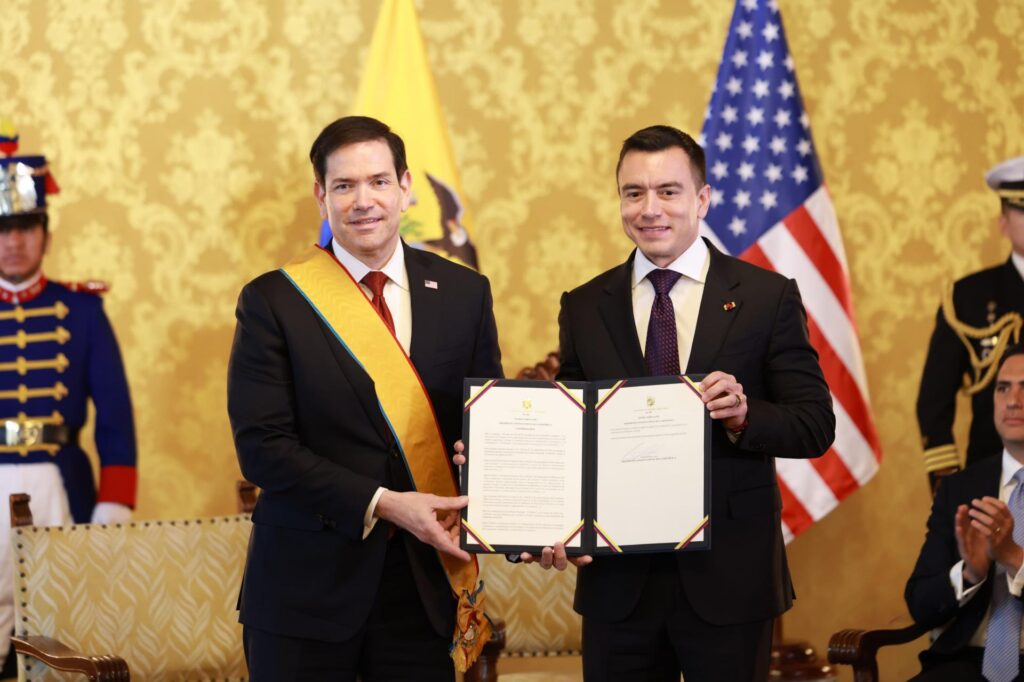 Daniel Noboa y Marco Rubio posan con un documento frente a las banderas de Ecuador y Estados Unidos.