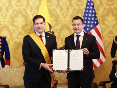 Daniel Noboa y Marco Rubio posan con un documento frente a las banderas de Ecuador y Estados Unidos.