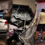 Un automóvil entre escombros y estructuras dañadas en el interior de una vivienda.