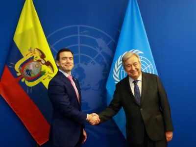 Daniel Noboa y António Guterres se estrechan la mano frente a banderas de Ecuador y Naciones Unidas.
