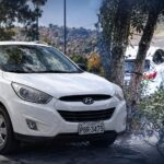 Composición de un vehículo Hyundai blanco estacionado y una escena captada por una cámara de seguridad.
