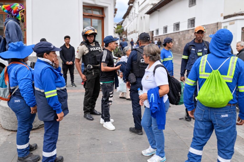 Trabajadores de limpieza, agentes y otros ciudadanos reunidos en una calle.