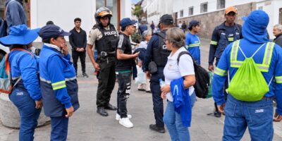 Trabajadores de limpieza, agentes y otros ciudadanos reunidos en una calle.