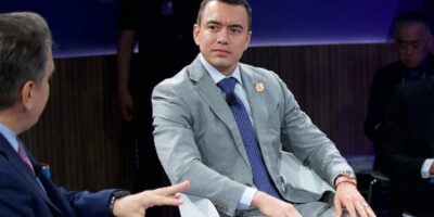 Daniel Noboa sentado durante una conversación en un foro.
