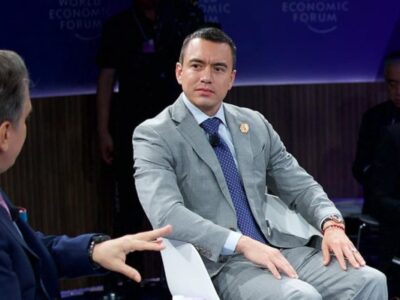 Daniel Noboa sentado durante una conversación en un foro.