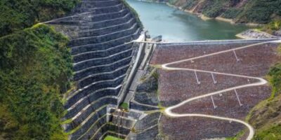 Vista aérea de una represa y un embalse rodeados de montañas.