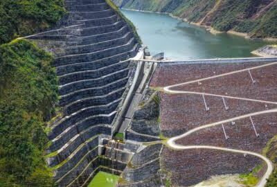Vista aérea de una represa y un embalse rodeados de montañas.