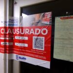Aviso de clausura de la Agencia Metropolitana de Control pegado en la puerta de un establecimiento.